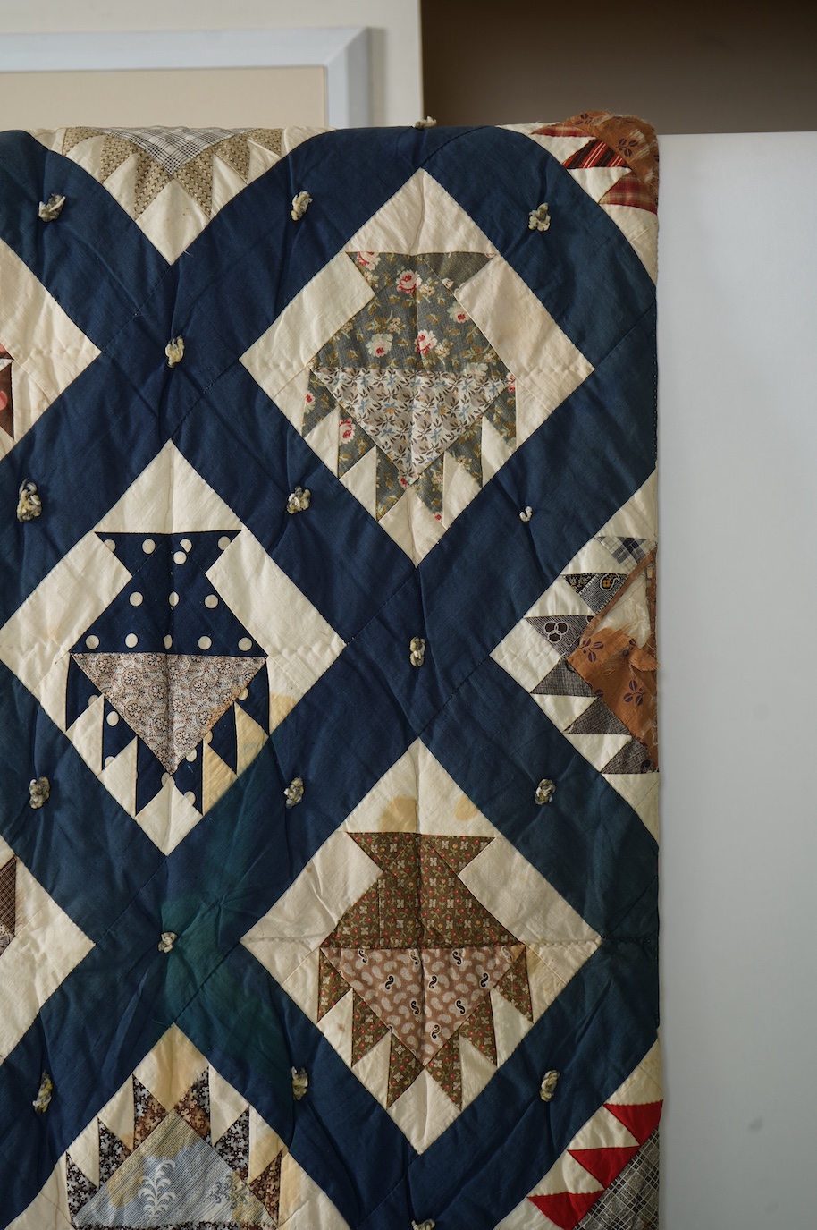 A bold handsome, American, Vermont 1865 (Civil War) ‘basket’ and lattice, hand quilted and piece tied bedcover, with an ornate floral backing. Worked with a plain navy cotton lattice border around central stylised printe